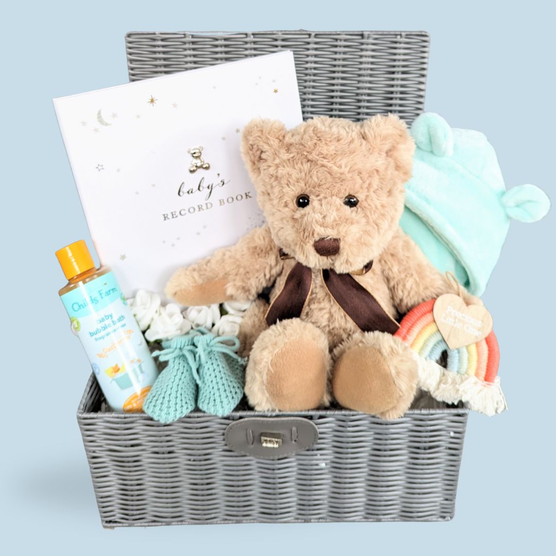 Beautiful new baby hamper gift. Presented in a grey wicker effect basket with baby bath robe, teddy bear, baby booties and milestone journal. The perfect gender neutral gifting option.