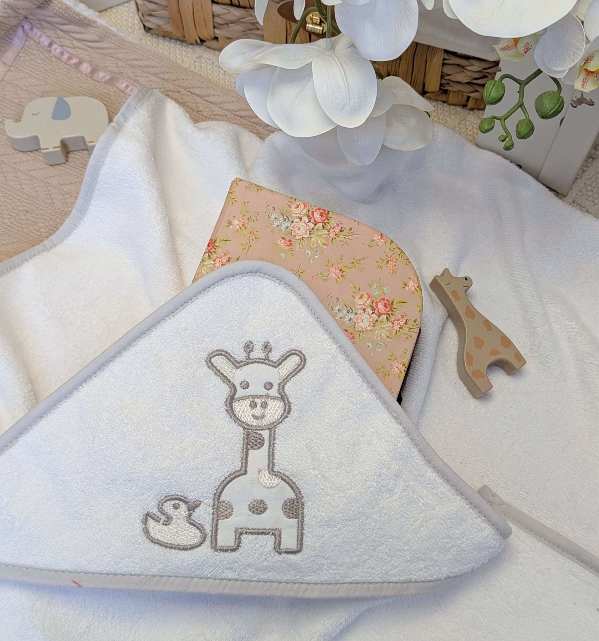 White hooded baby bath towel with a giraffe design.
