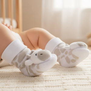 Baby wearing baby giraffe rattle socks with soft plush character detail, cosy baby clothes for newborn feet