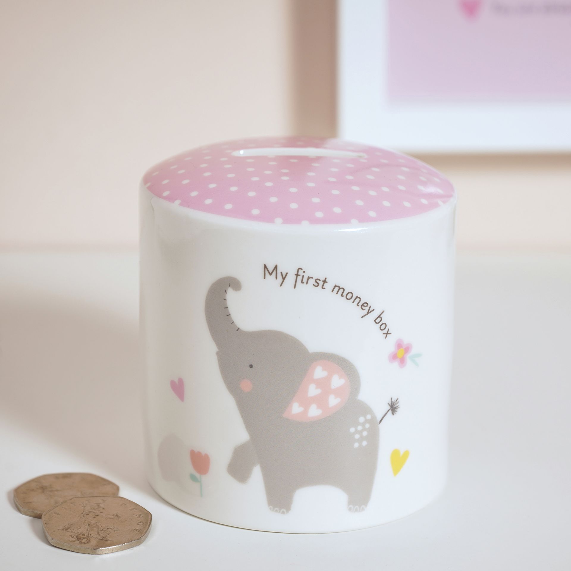 Children's money box with elephant design and pink top on a light background