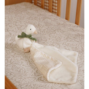 Goose plush comforter laid on patterned bedding with its cream side folded back