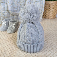 Knitted grey pompom hat for a baby.