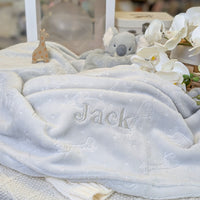 Baby blanket which is grey and embossed with animals and fleece