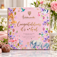 Pink chocolate box with a message on the front for a newborn baby girl ’Congratulations It's A Girl’ On a lifestyle background 