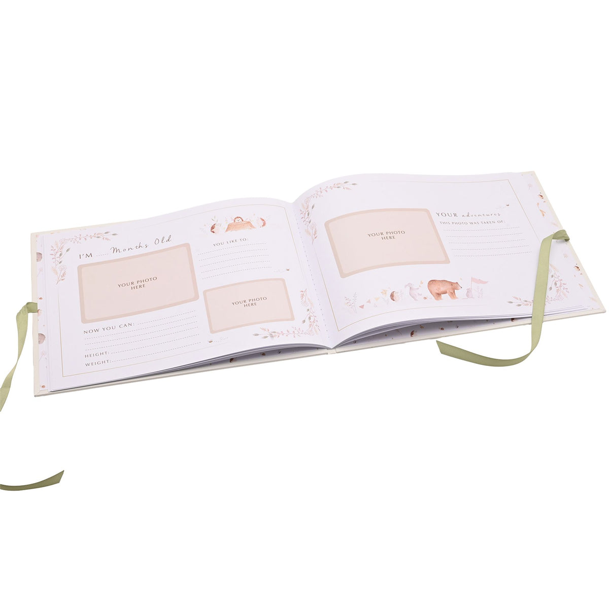 Baby memory book open to illustrated gratitude pages, with its green ribbon resting alongside.