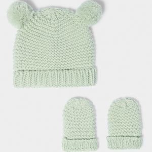 Light sage knitted newborn hat and mittens set displayed on soft neutral background
