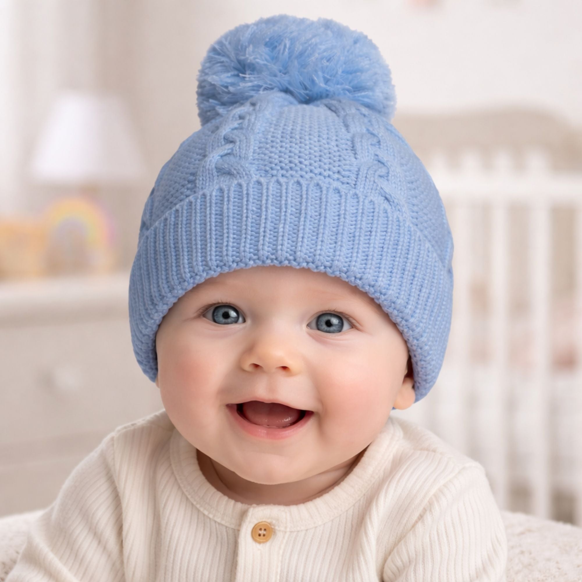 Knit blue baby hat with a pompom