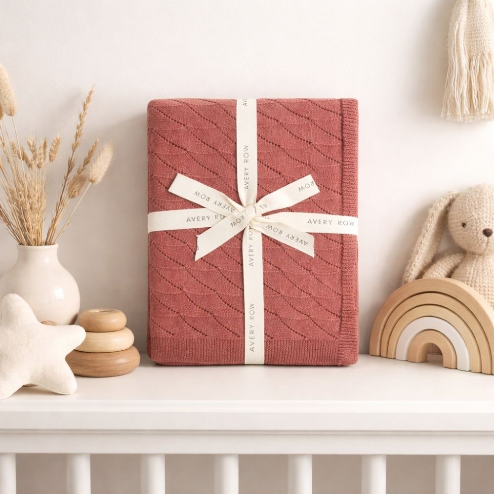 Dusky pink knitted baby blanket which is made from organic cotton.