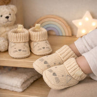 Beige knit baby booties with a little cat face