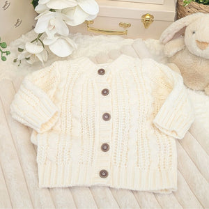 White knitted cream cardigan with wooden buttons.