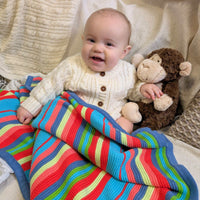 Colourful striped baby blanket with a baby