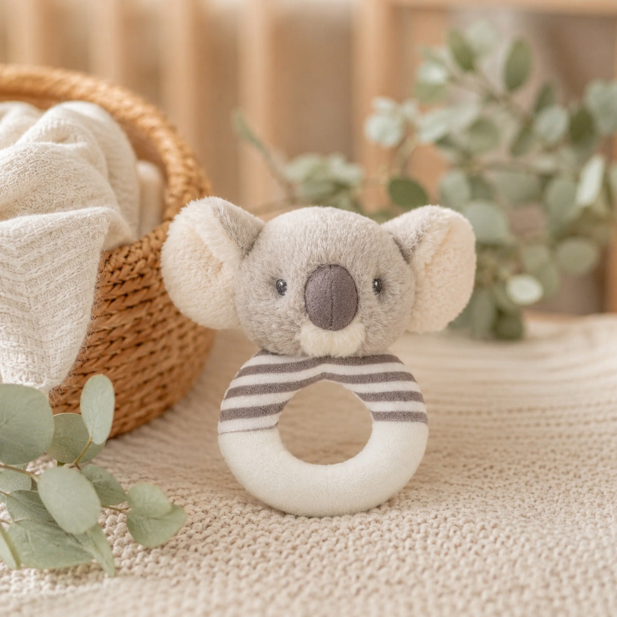 Soft plush koala baby ring rattle toy with a gray face and striped cream and gray ring. 14cm grip toy sized for small hands