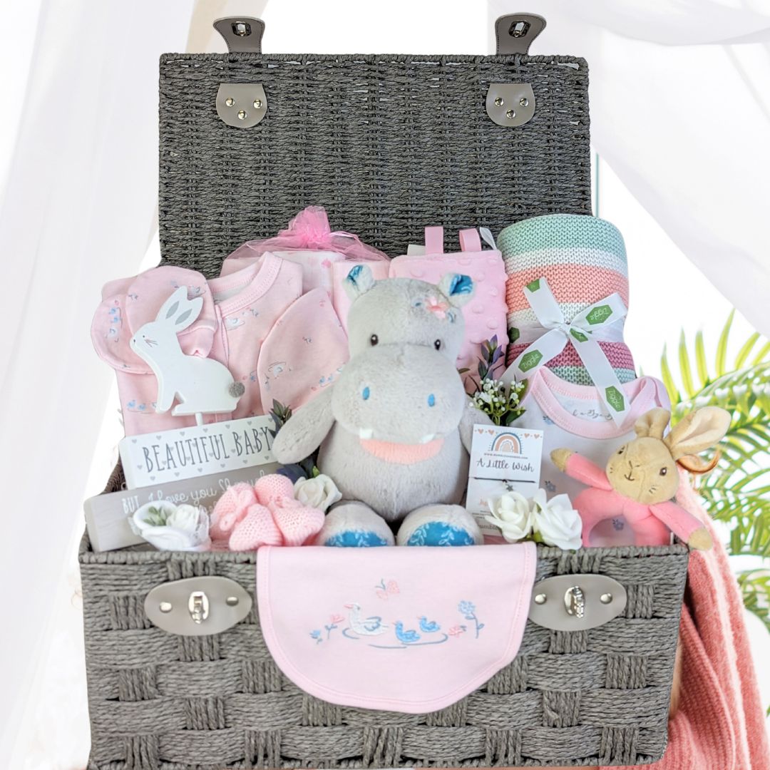 large baby girl hamper with pink clothing set, muslins, blanket, toys and taggie blanket.