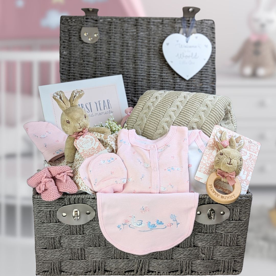 baby hamper gifts with pink clothing set, baby journal, flopsy bunny and knit blanket.