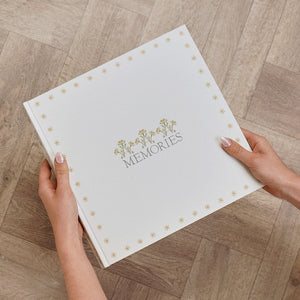 Hands holding the neutral floral MEMORIES photo album