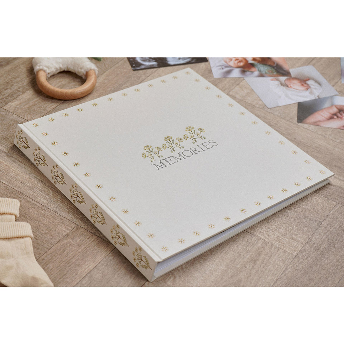 Floral linen memories photo album resting on a wooden surface among photographs