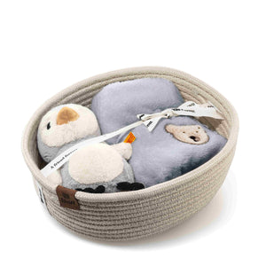 Lio penguin rattle and folded grey bib arranged inside a cream cord storage basket with a presentation ribbon.