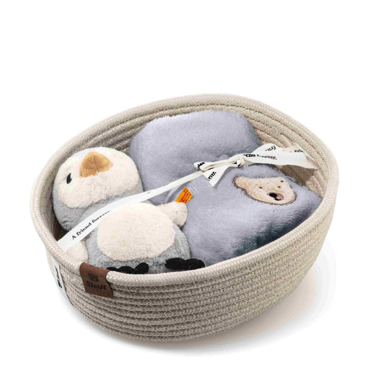 Lio penguin rattle and folded grey bib arranged inside a cream cord storage basket with a presentation ribbon.