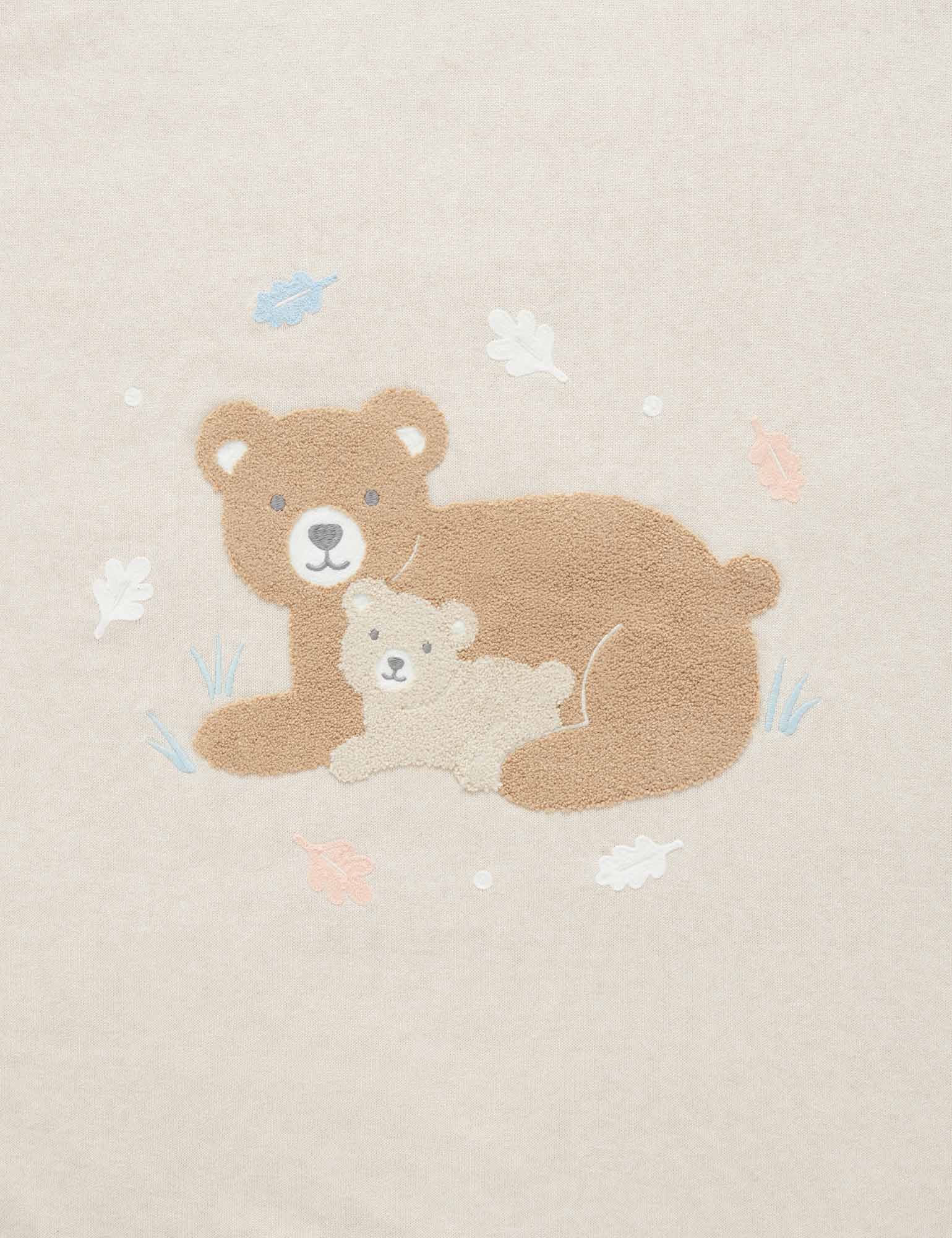 Close up of Little Bear embroidered baby blanket in organic cotton with fluffy chenille bear and soft neutral background.