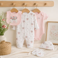 Baby clothing set with floral patterns and says 'little love' on the bib in embroidery