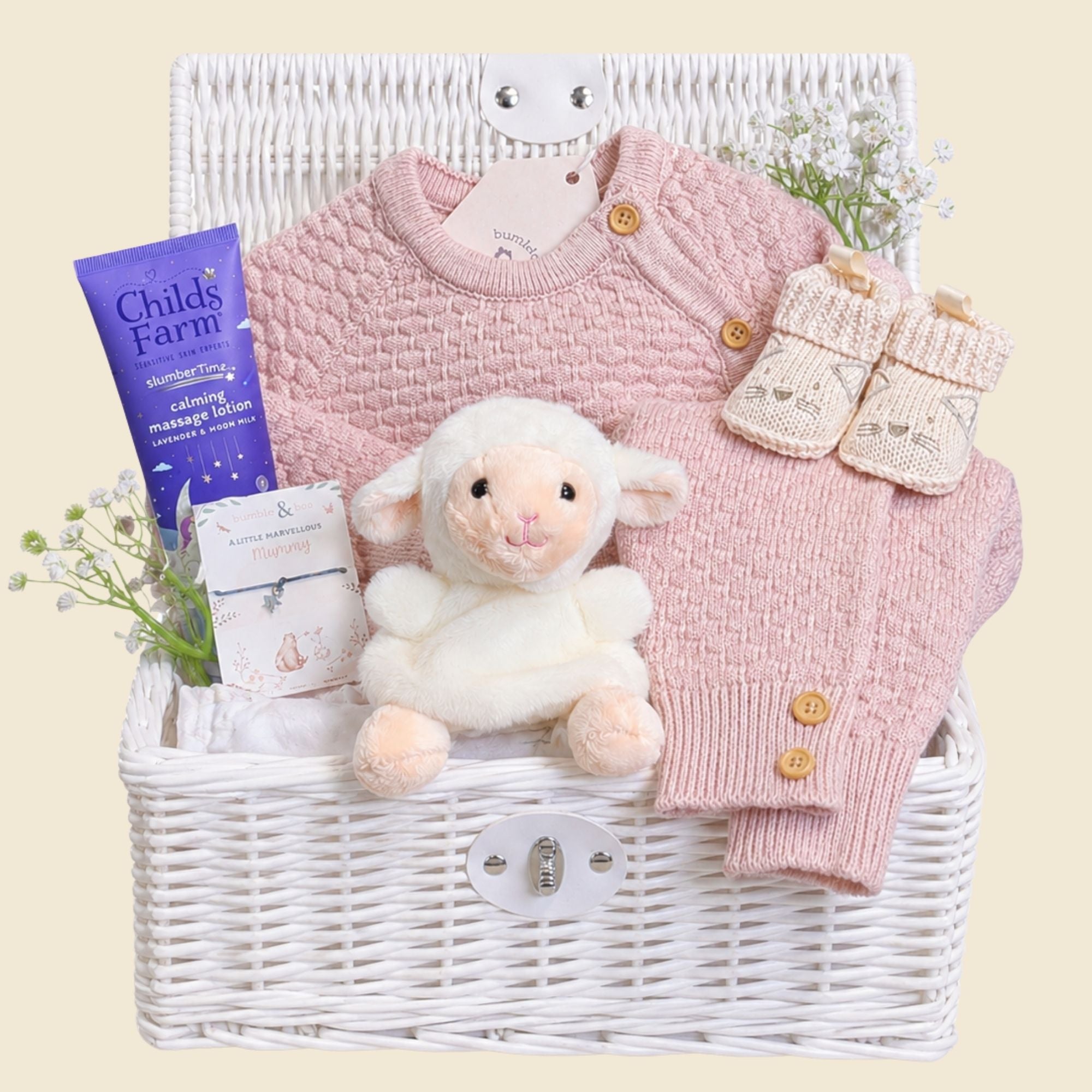 Luxury baby girl gifts in a hamper basket with dusty pink knit clothing set and a lamb toy.