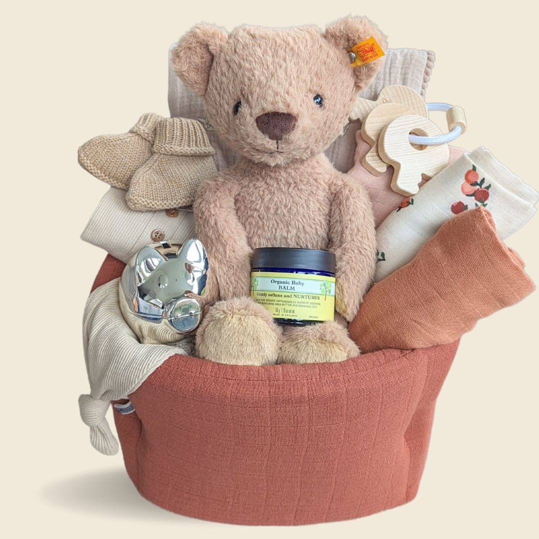 New baby hamper with teddy bear and organic clothing and blanket.