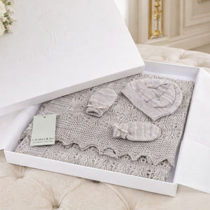 A gift for a newborn baby which includes grey cashmere blanket, hat and mitten set.