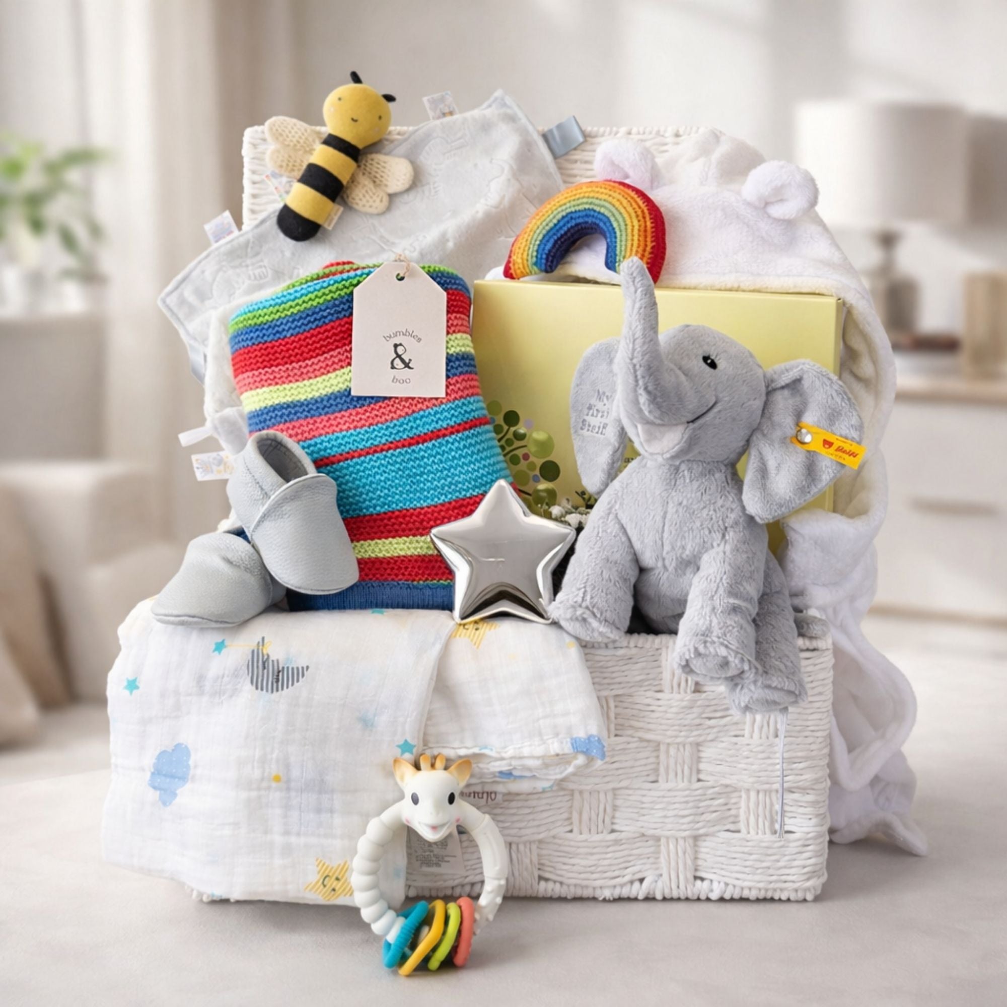 Luxury gifts in a basket to welcome a new baby. Presents include Steiff elephant soft toy and Neals Yard skincare.