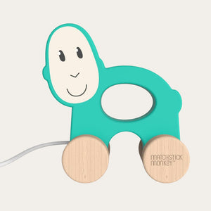 Teal monkey wooden pull toy with a smiling face, branded 'Matchstick Monkey'