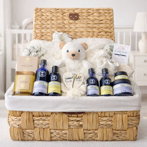 Gifts for expecting parents in a wicker basket with a cream bear and neals yard remedies