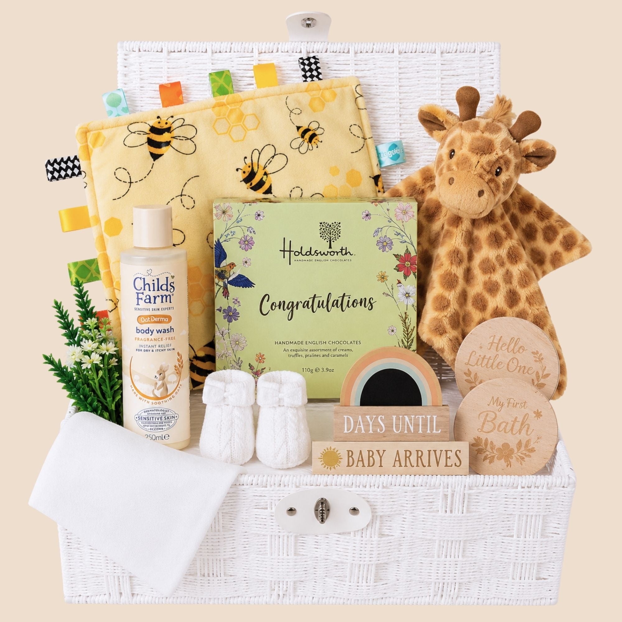Mum to be gifts in a white basket to include chocolates for the parents and giraffe themed presents