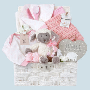 Mum to be hamper in soft pinks and creams featuring gifts including lamb soft toy. 
