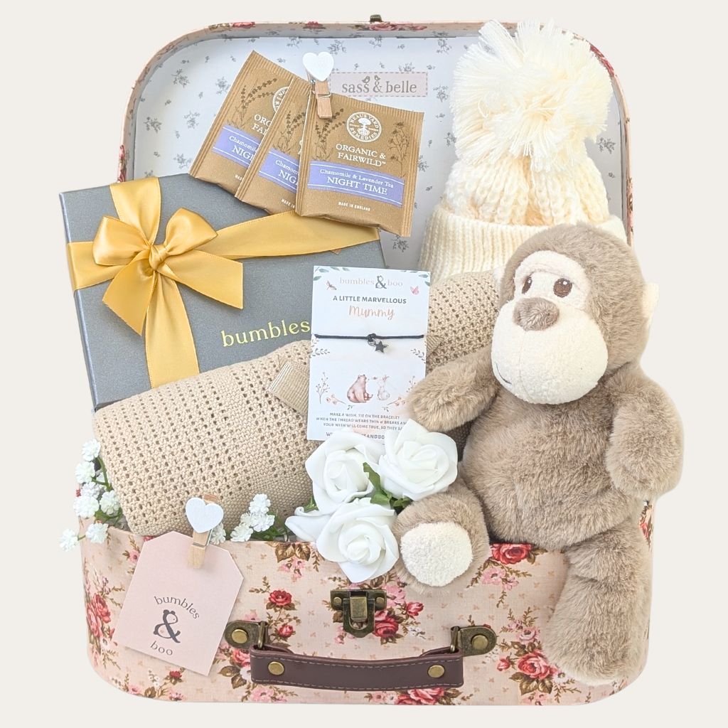 Mum to be hamper with pregnancy gifts in a vintage rose luggage trunk with presents including monkey soft toy and chocolates