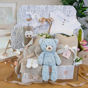 Mummy to be pregnancy gift box with white baby clothing, blue teddy and chocolates for mum