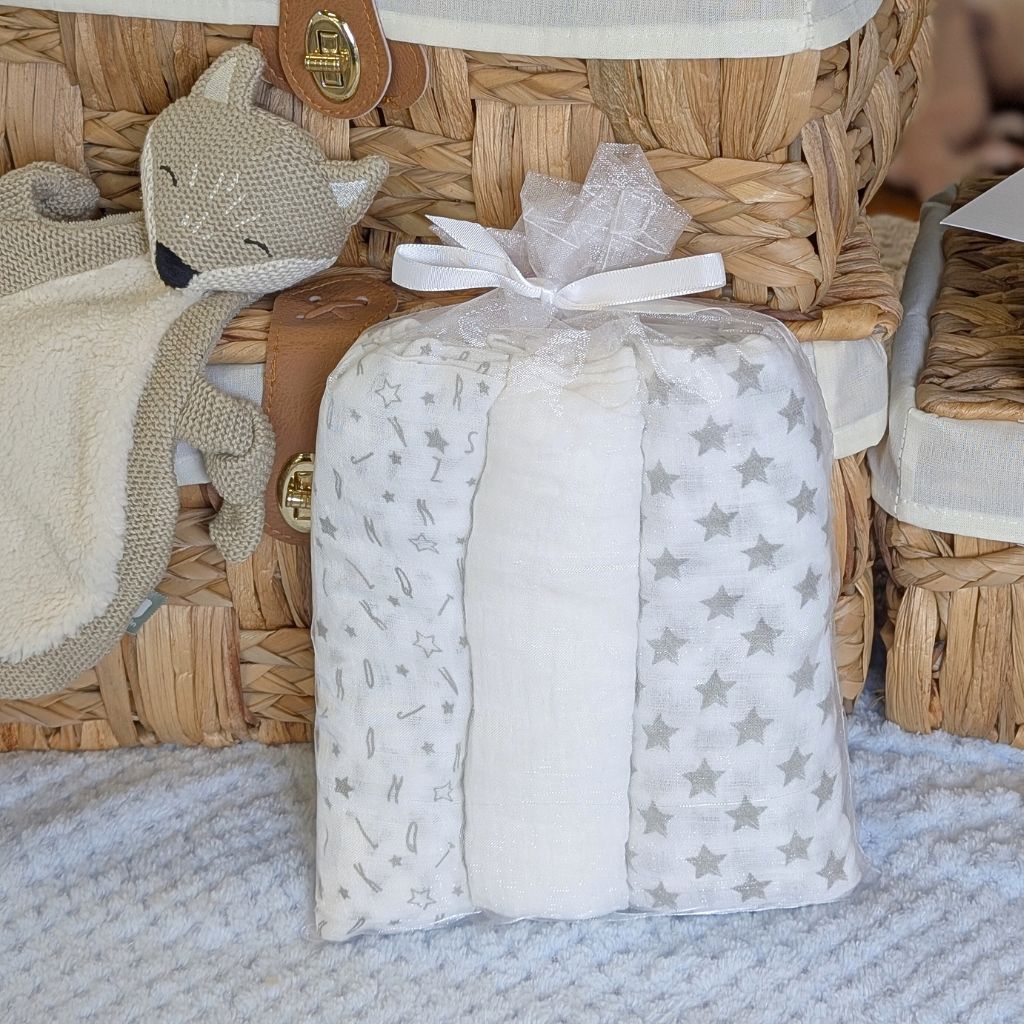 Muslin squares in a gift back which are grey and white with stars.