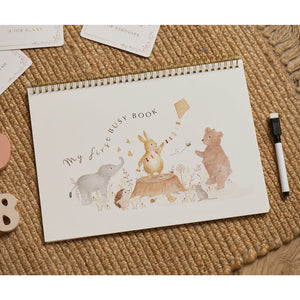 My First Busy Book on a woven surface, with illustrated animal characters on its cover and a pen beside it.