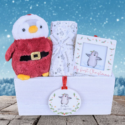 Christmas baby gift box with penguin soft toy.