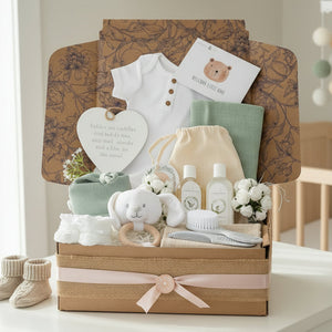 Neutral new baby gifts hamper box with presents for a newborn including clothes and accessories in white and sage green by Bumbles and Boo.