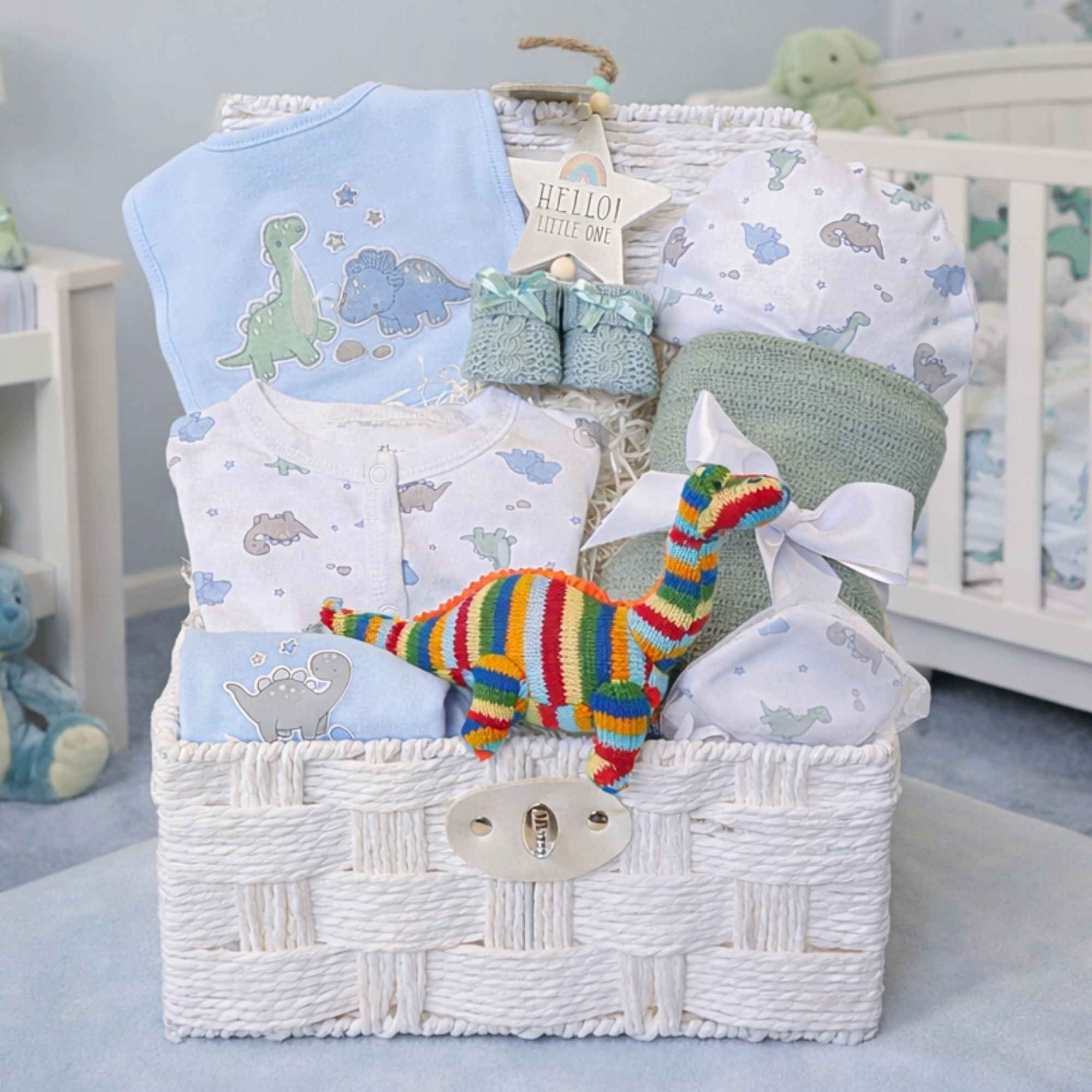 Dinosaur baby boy gift basket with clothing and an organic dinosaur rattle.