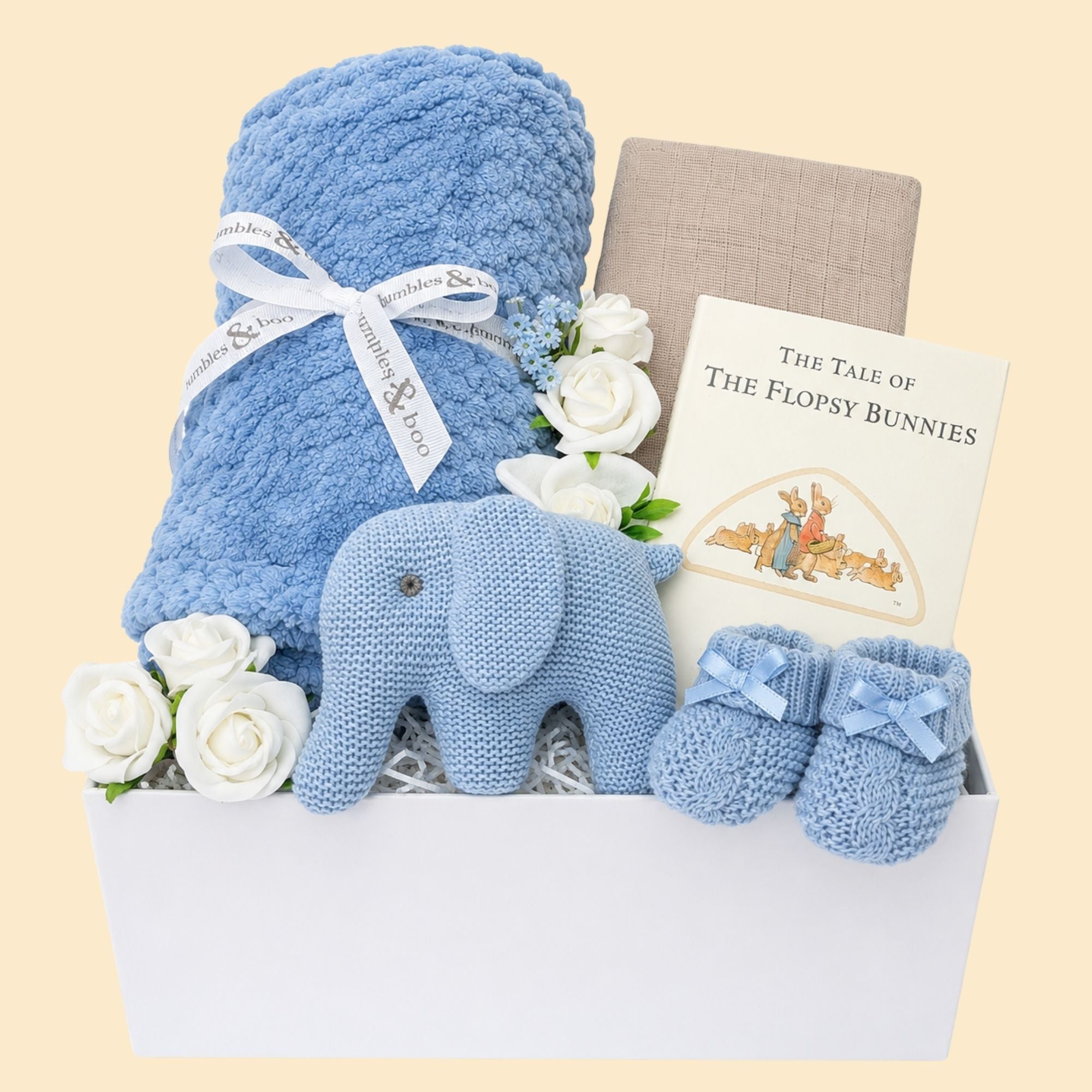 Baby boy gifts in a box with dusky blue blanket and blue elephant rattle. Hamper designed by Bumbles and Boo.
