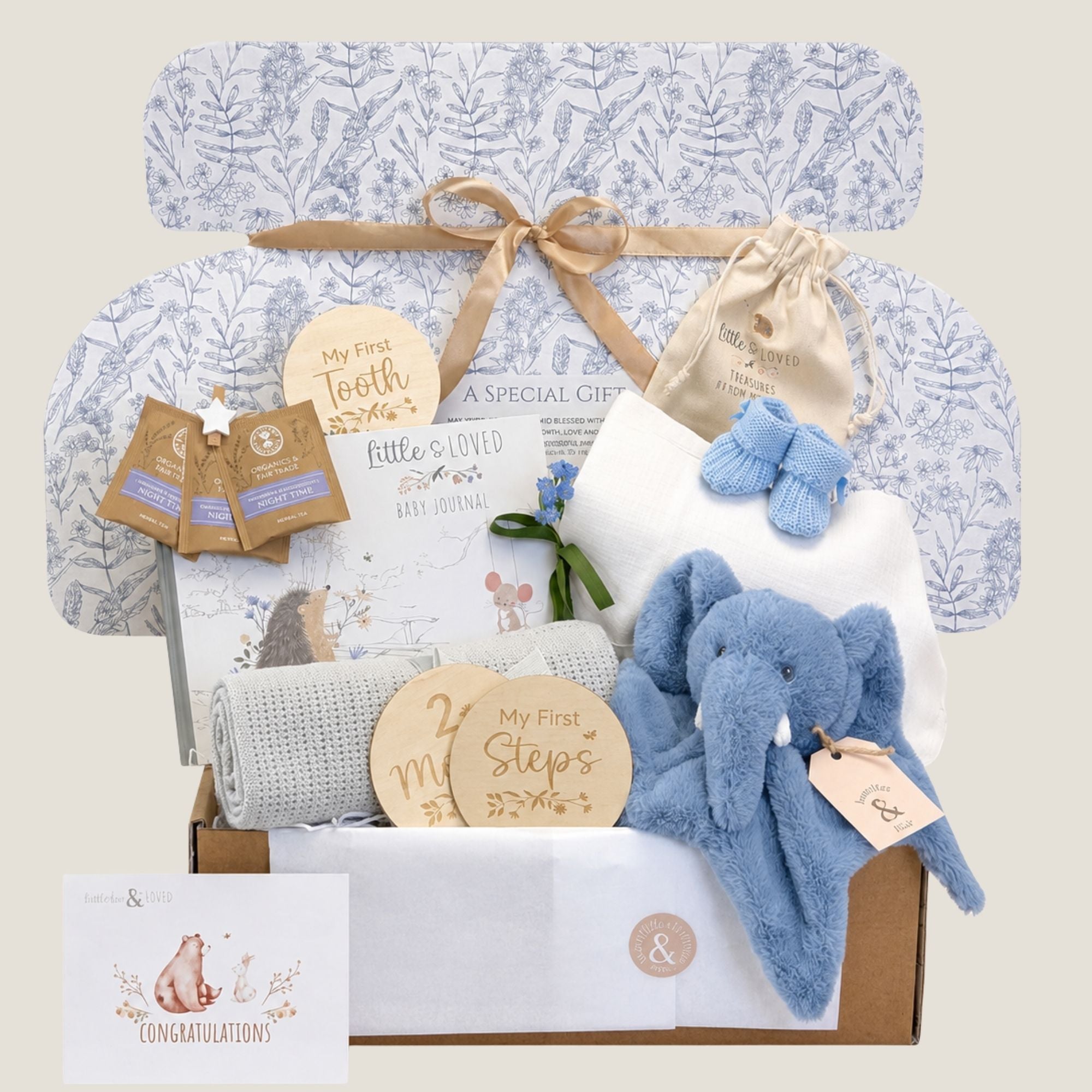 Baby boy gifts box with blue elephant toy, blanket, and presents for a newborn