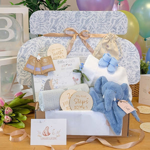 Baby boy gifts box with blue elephant toy, blanket, and presents for a newborn