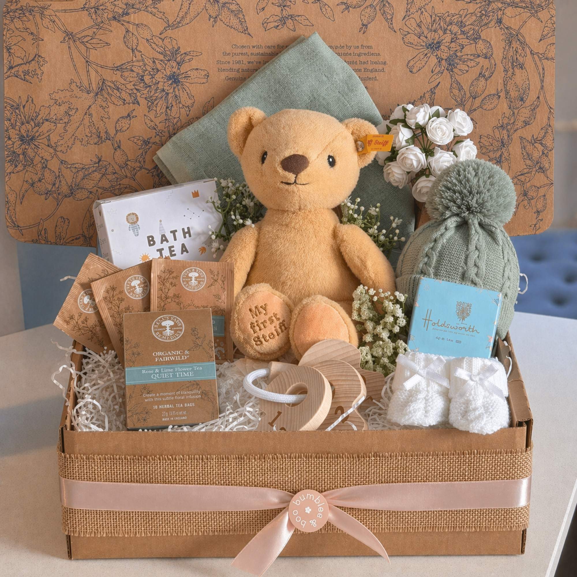 New baby hamper gifts box with steiff teddy bear and sage green baby clothes in an eco friendly postal box by Bumbles and Boo.