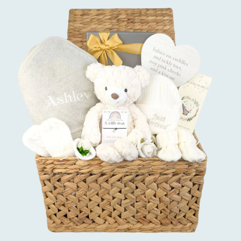 New baby gifts basket packed with white newborn presents. This gift hamper includes personalised baby towel