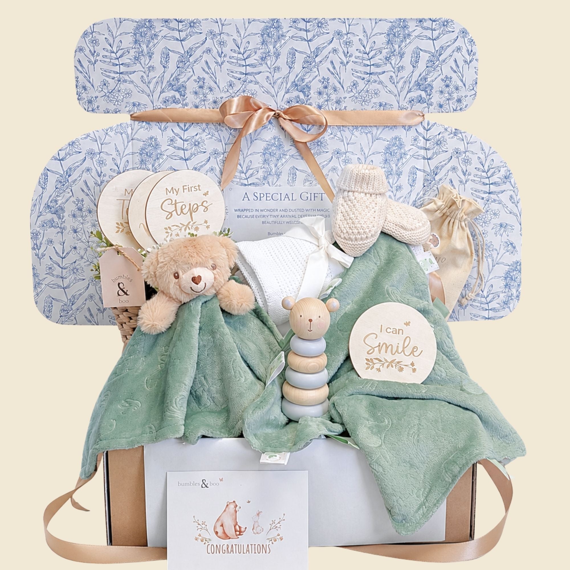 New baby gifts box with presents in this hamper including sage green teddy toy, matching comforter and wooden toy.