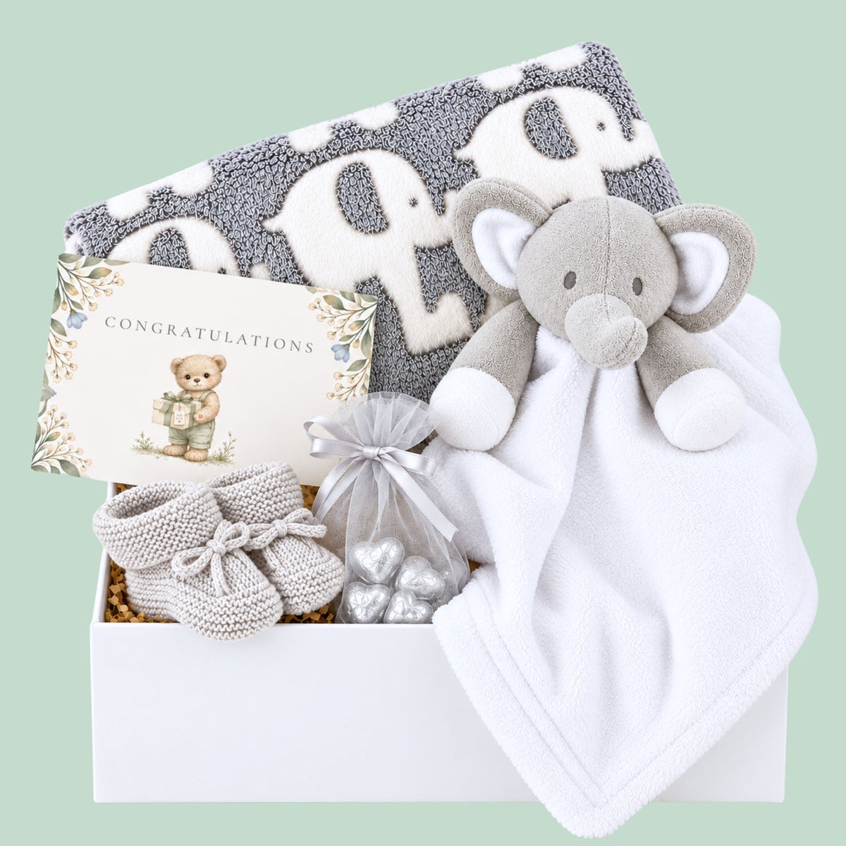 Baby hamper box with gifts including grey blanket with elephant print, white and grey baby comforter and a gift for mum.
