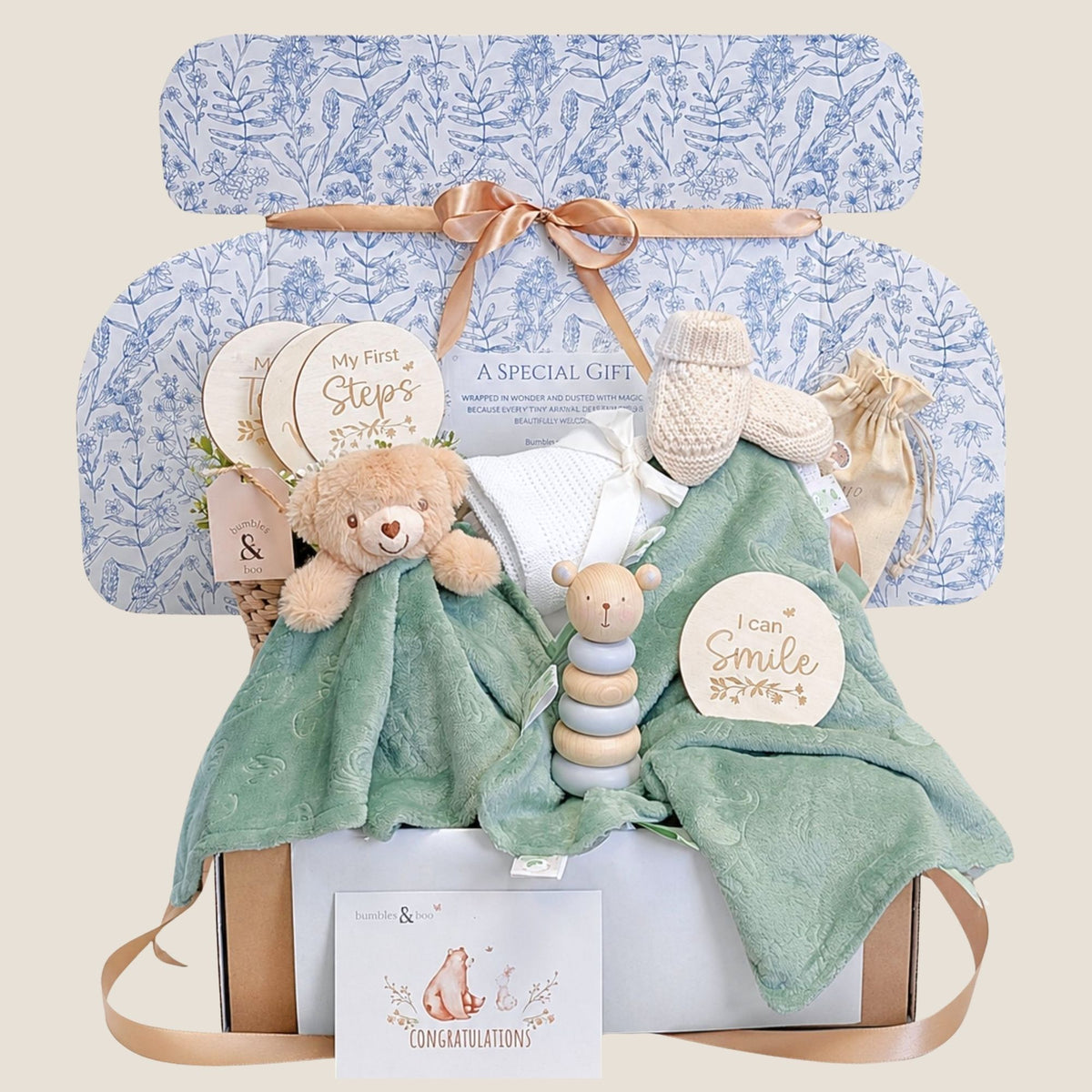 New baby gifts box with presents in this hamper including sage green teddy toy, matching comforter and wooden toy.