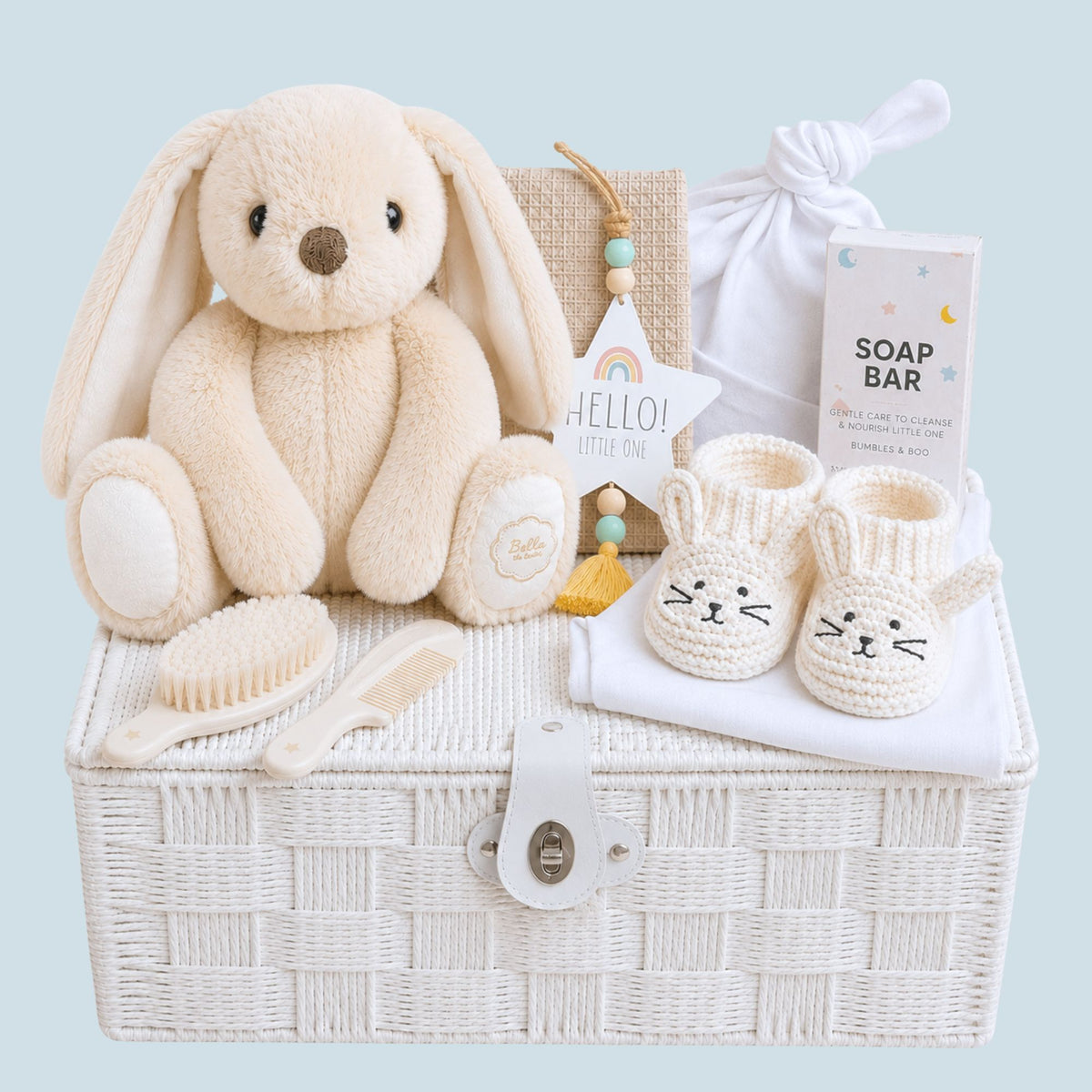 New baby hamper basket with gifts including a soft white bunny, booties, newborn hat and gentle bath-time product. 