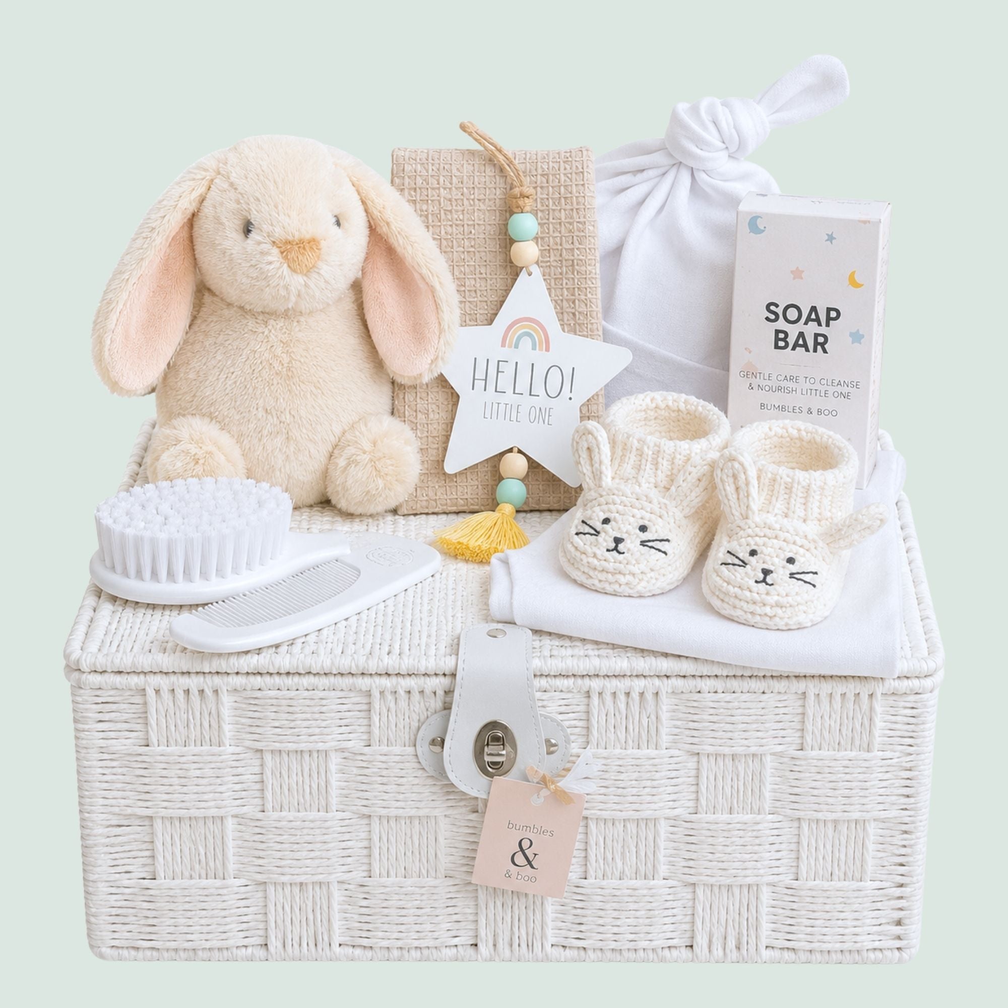 New baby gifts box hamper with white presents. This gift hamper features a soft bunny, booties, newborn hat and gentle bath-time product. 
