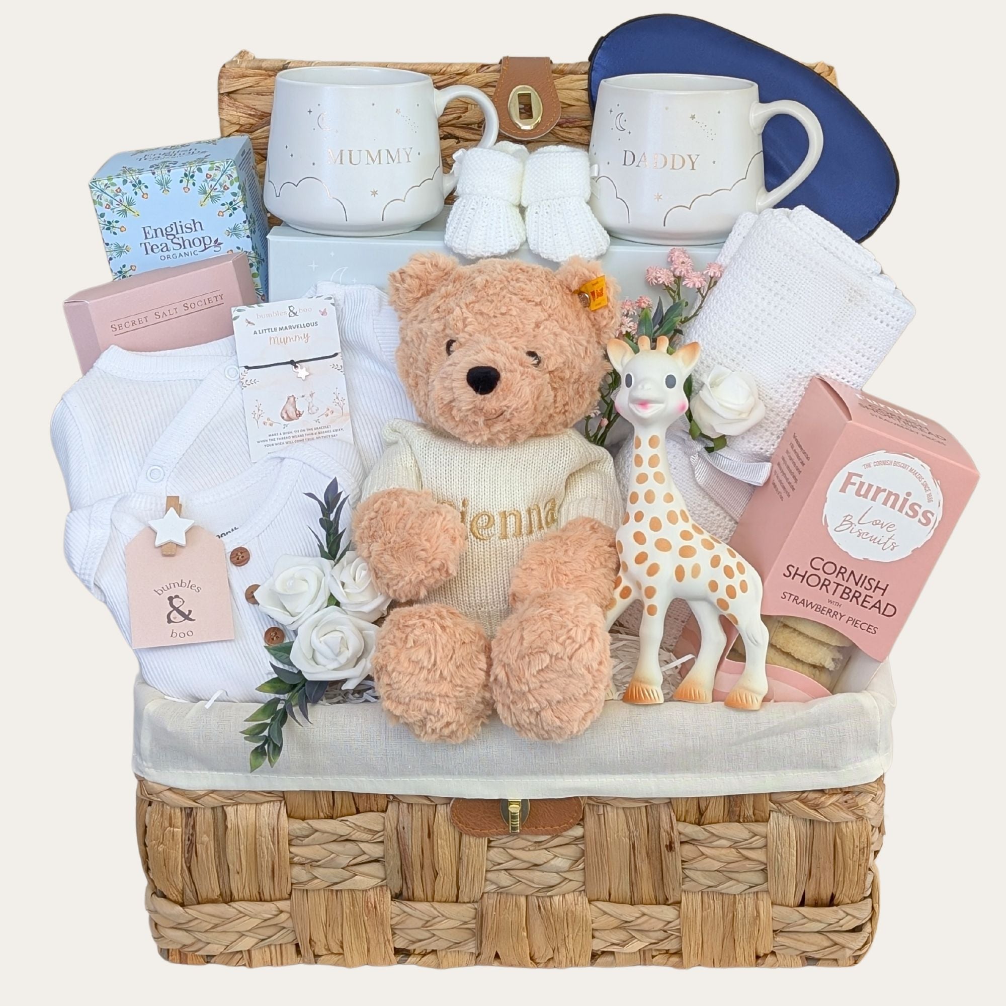 New mother hamper basket with gifts for mum and dad including mugs, biscuits, eye mask, teddy bear and baby clothing.